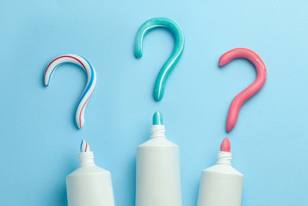 Trois tubes de dentifrice avec chacun du dentifrice en forme de point d'interrogation pour symboliser la question suivante : quels sont les avantages d'un dentifrice pour enfants  sans fluor ?